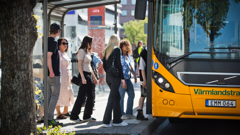 Personer som går på en gul regionbuss vid hållplatsen Inre hamn.