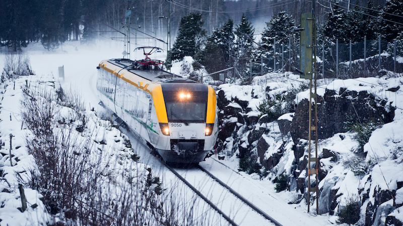 Ett tåg framifrån som åker i ett vinterlandskap.
