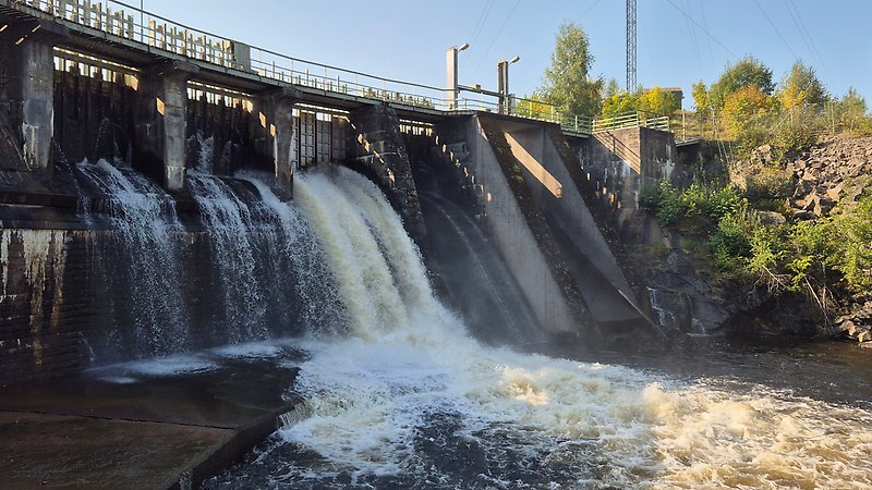 Som från ett vattenfalla forsar vatten från ett vattenkraftverk.